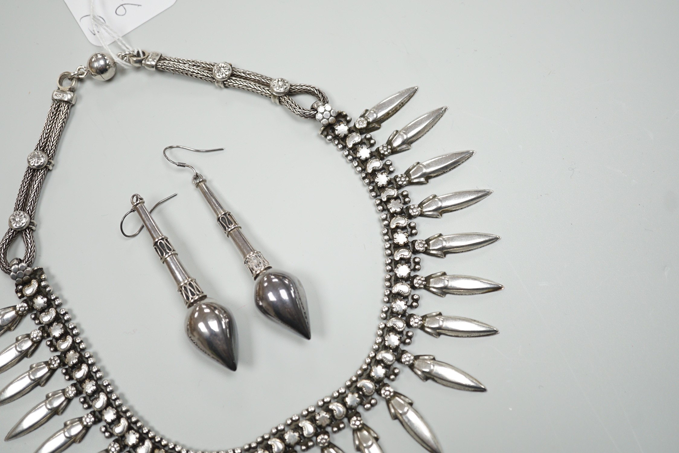 A late 20th century Balinese 925 white metal drop fringe necklace, 43cm, together with a pair of white metal drop earrings, 63mm.